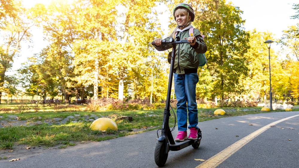 Holčička na koloběžce v parku_03