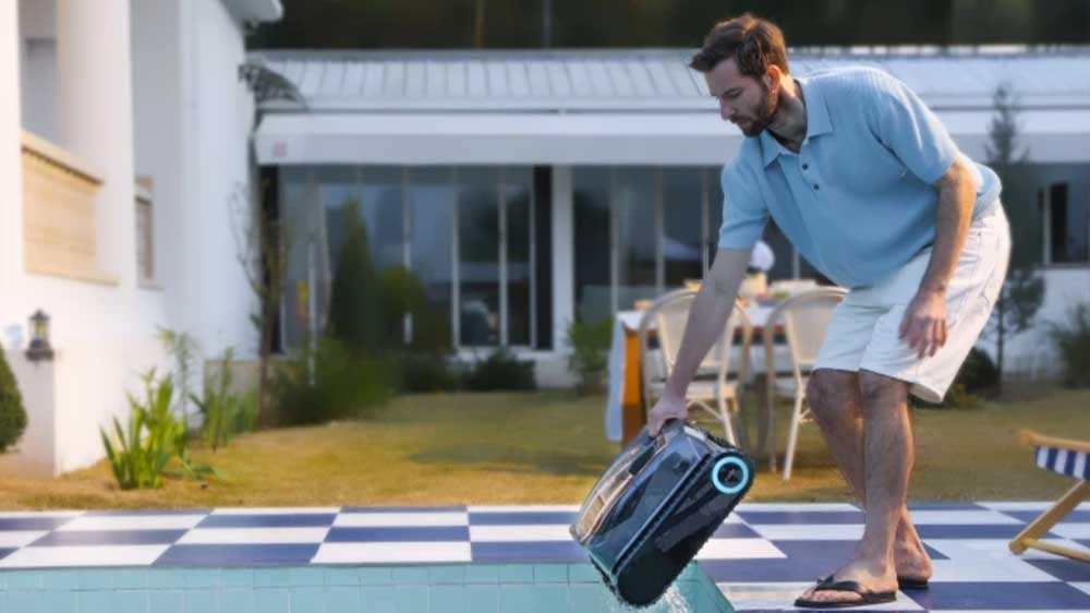 Muž vyndávající bazénový vysavač Aiper Scuba X1 z bazénu_02