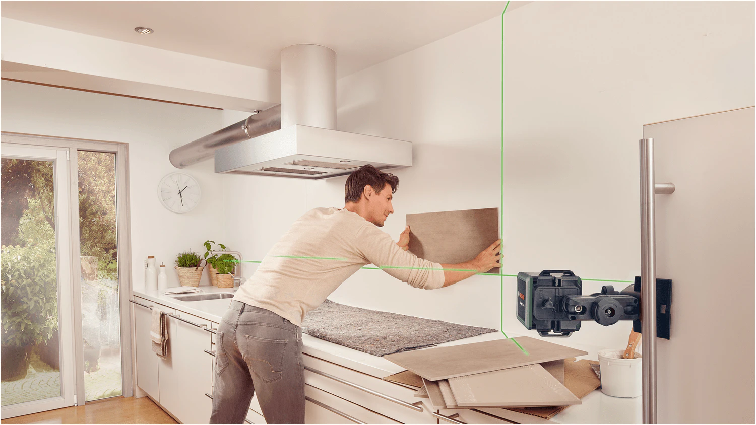Muž obkládající kuchyň pomocí laseru Bosch 0.603.663.CZ1