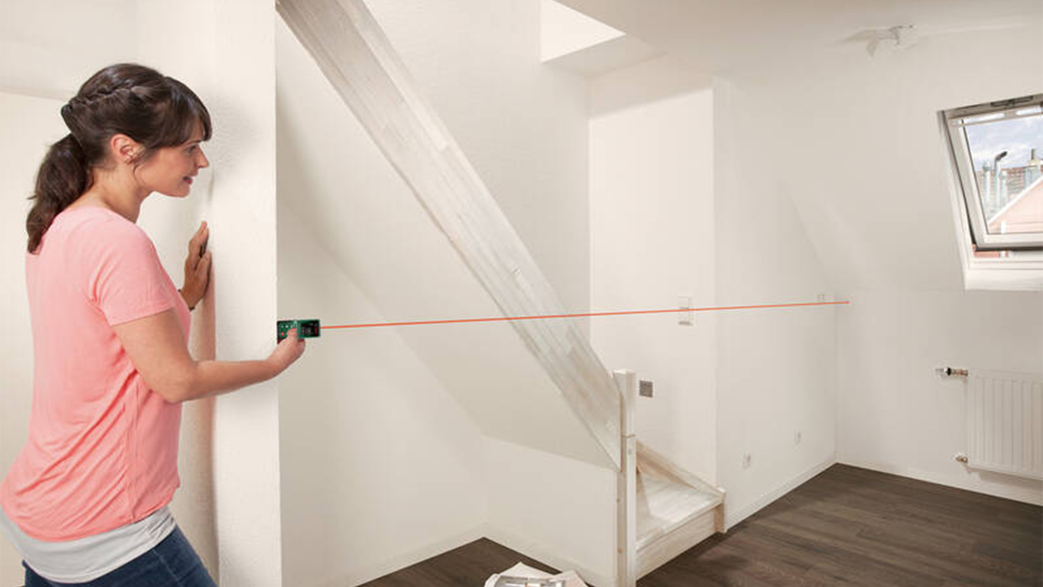 Žena použ&iacute;vaj&iacute;c&iacute; laserov&yacute; d&aacute;lkoměr Bosch Universal Distance 50