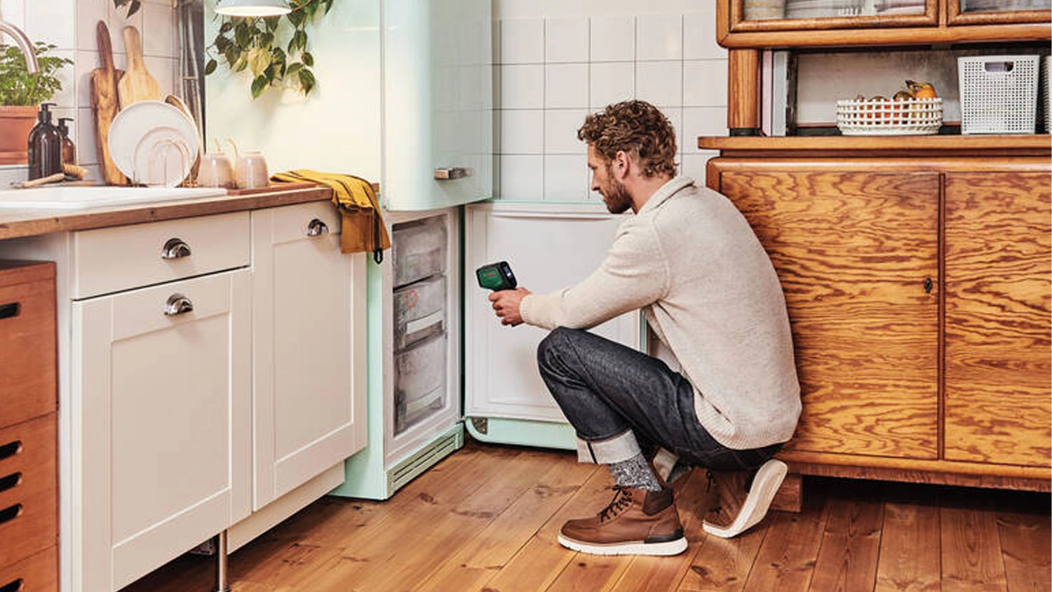 Muž měří teplotu na mrazáku termodetektorem Bosch AdvancedTemp