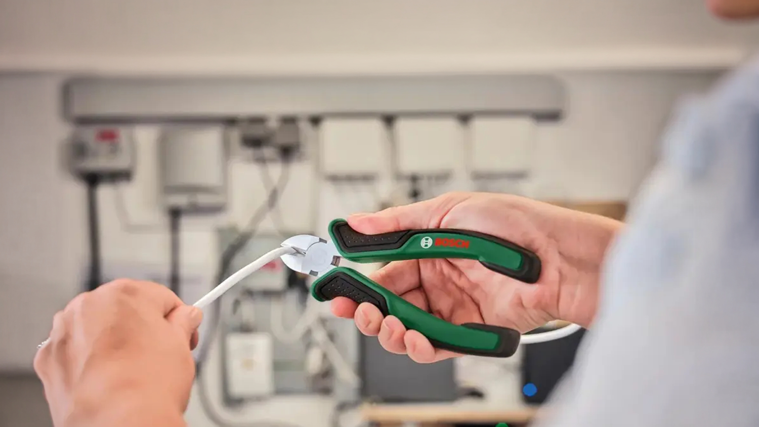 Muž &scaron;t&iacute;pe kabel pomoc&iacute; kle&scaron;t&iacute; ze sady Bosch 1.600.A02.C0S