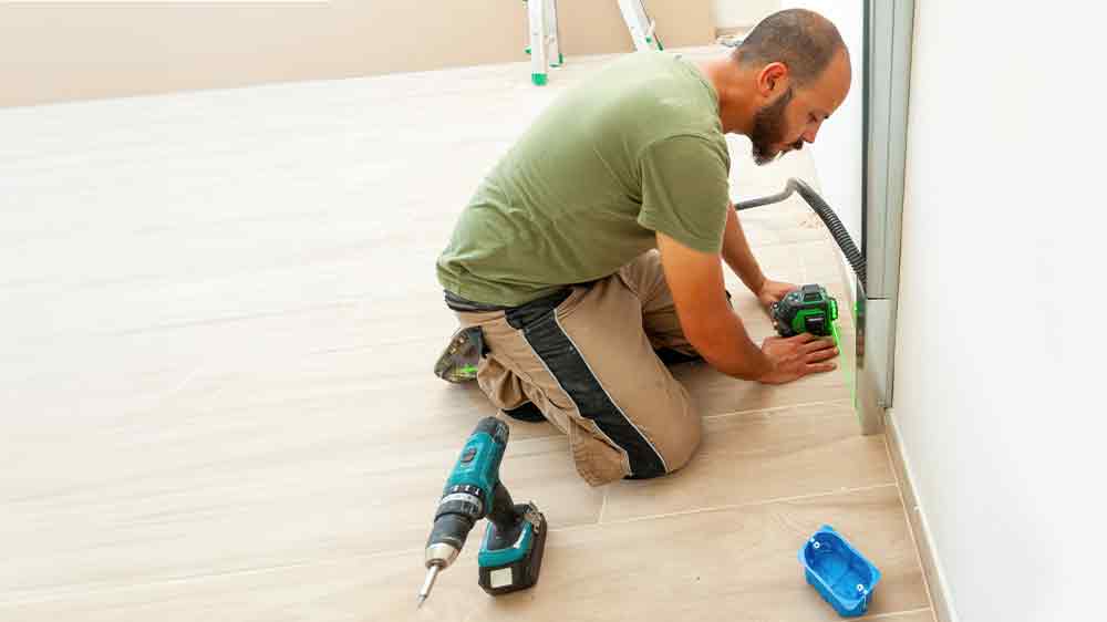 Muž merací inštaláciu zariadenia krížovým laserom _03