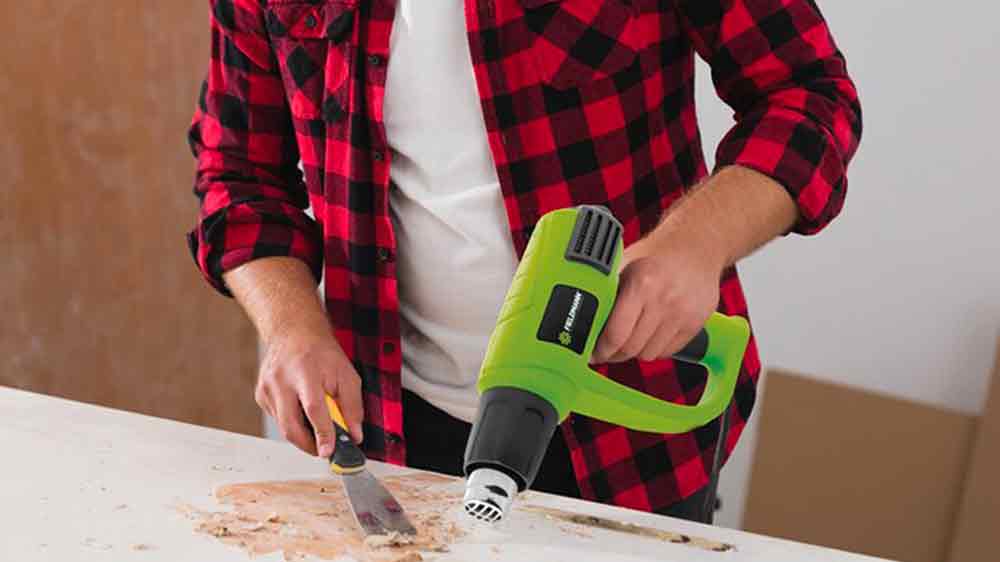 Muž pracuje s horkovzdušnou pistolí Fieldmann_02