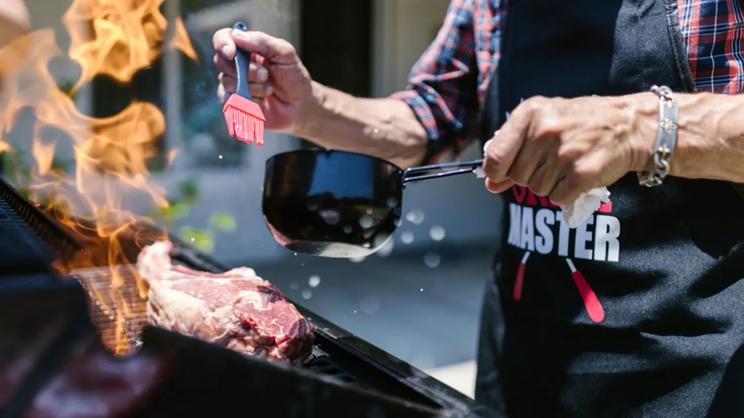 Muž u grilu chce potřít maso