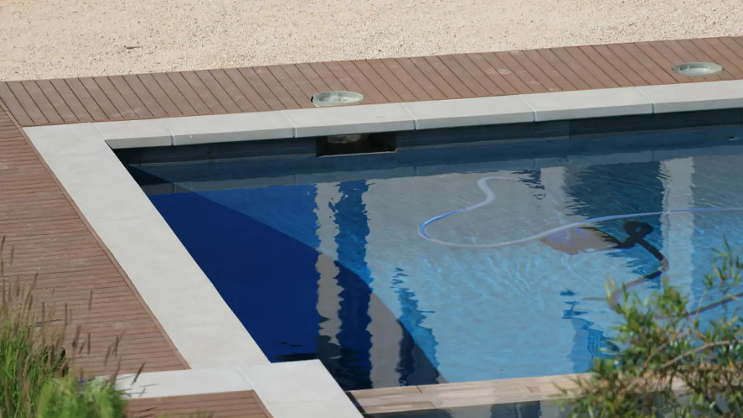 Pohled na roh baz&eacute;nu s vysavačem ve vodě