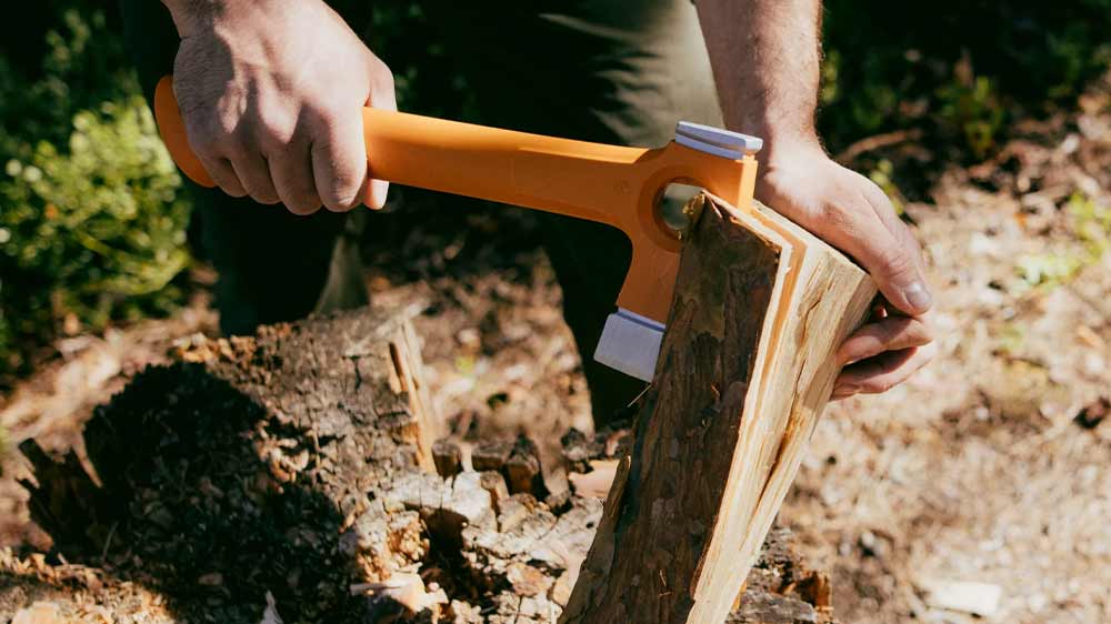 Muž seká do polínka univerzální sekerou Fiskars X13_03