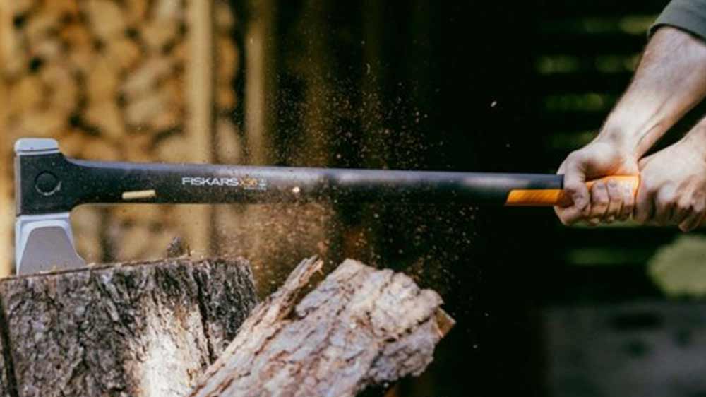 Muž seká se štípací sekerou Fiskars X36_02