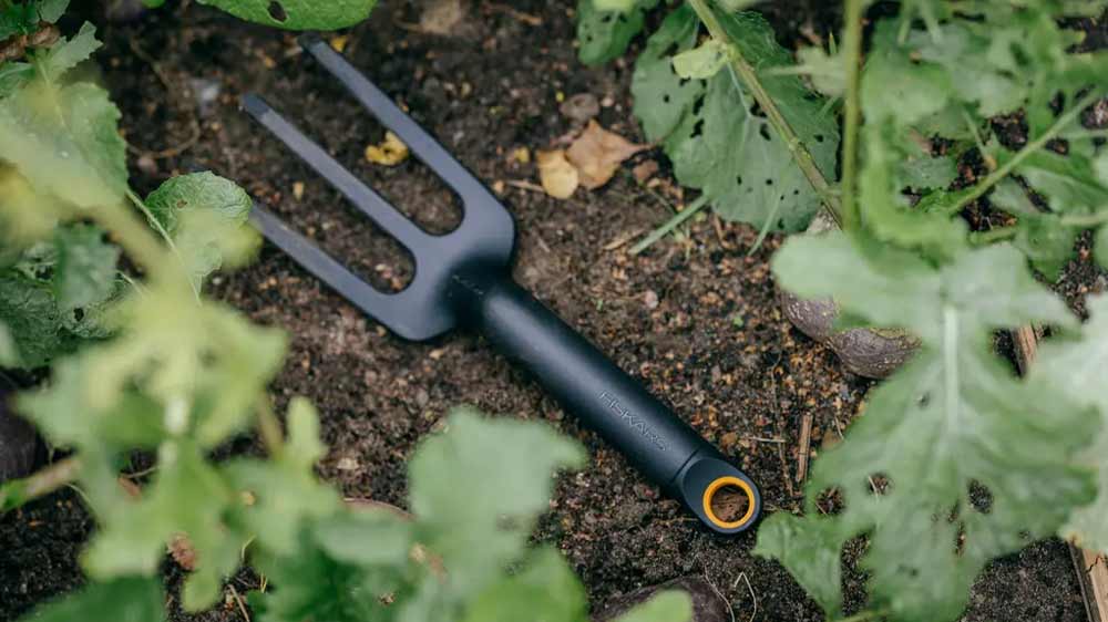 Vidle na plevel Fiskars Solid ležící na zemině_02