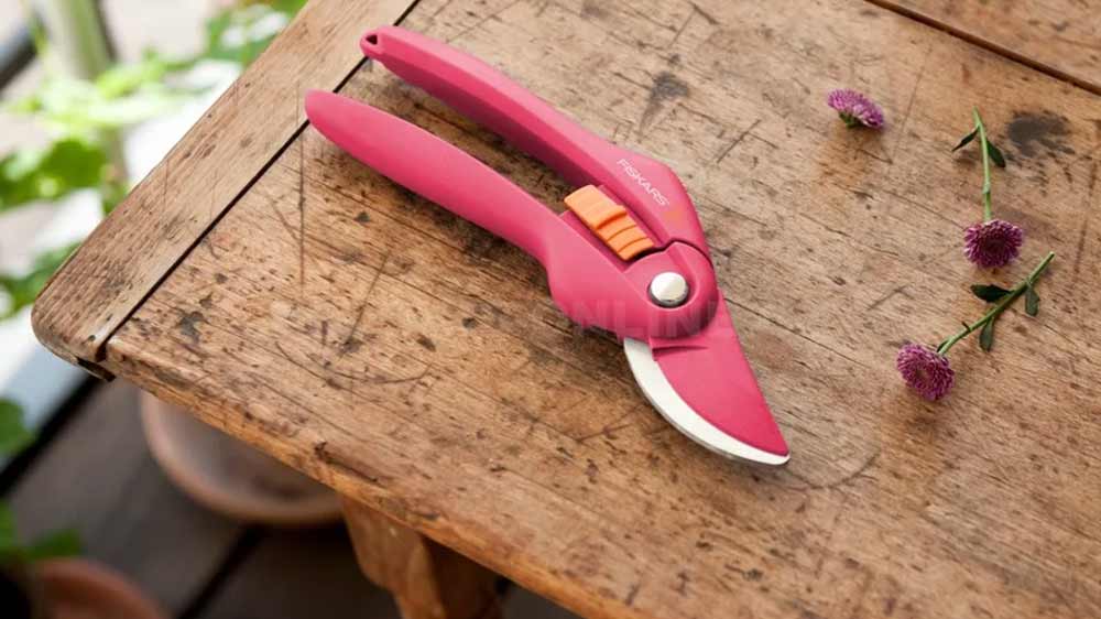 Zahradní nůžky Fiskars Ruby P26 1003657 položené na zahradním stole_02