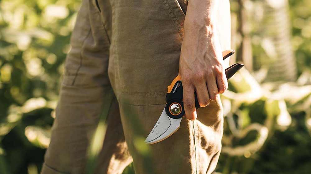 Muž v zahradě s dvoučepelovými zahradními nůžkami Fiskars_02