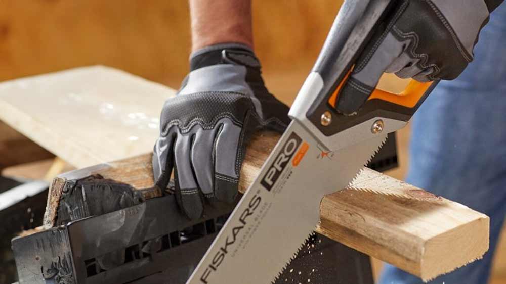 Muž řeže s ruční pilou Fiskars Power Tooth_02