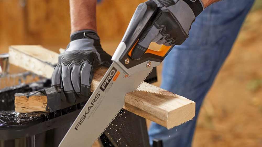 Muž řeže s ruční pilou Fiskars_02