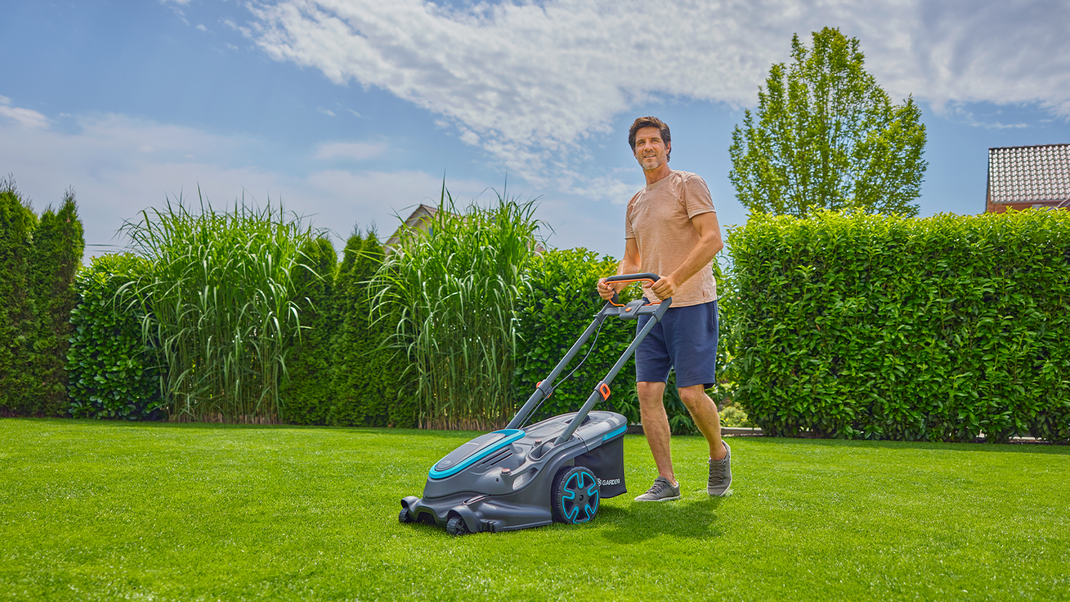 Muž kosí trávu s kosačkou Gardena PowerMax Duo 46/36V