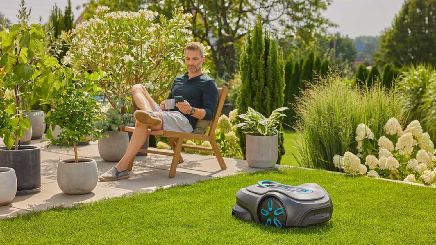 Muž ovláda robotickú kosačku pomocou mobilného telefónu