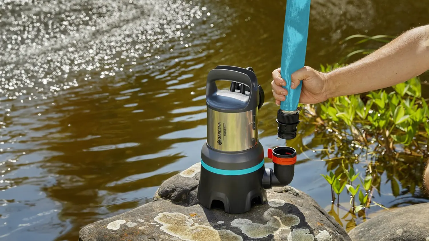 Osoba připojující čerpadlo GARDENA nad jezírkem