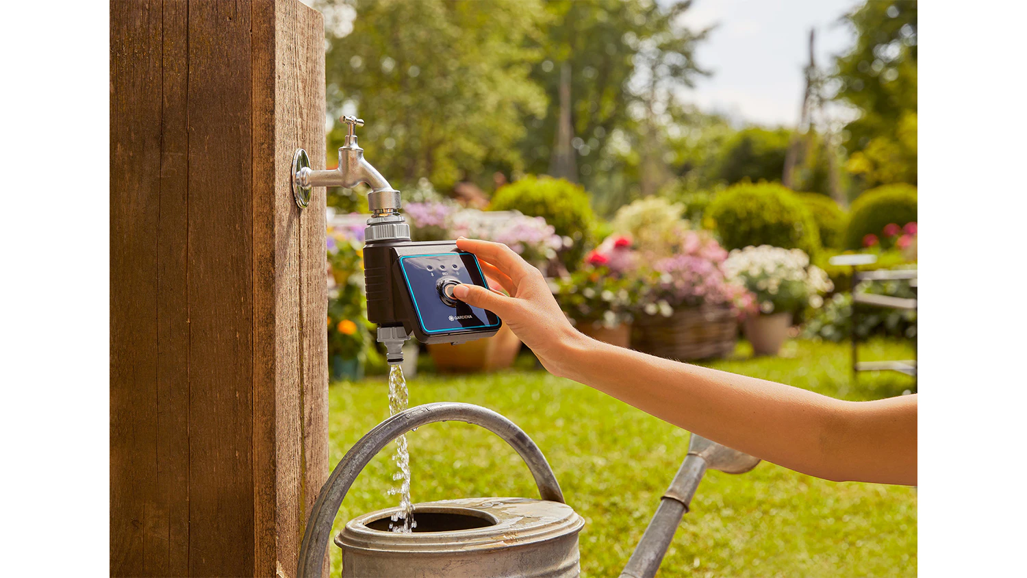 Žensk&aacute; ruka nastavuje zavlažovac&iacute; poč&iacute;tač GARDENA Bluetooth