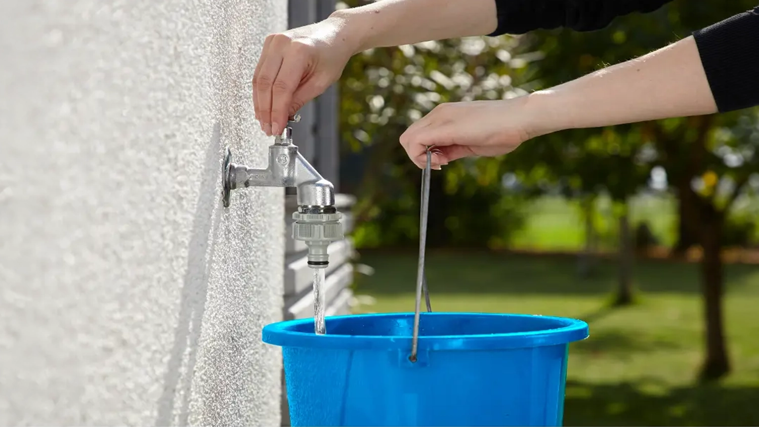 Žena púšťa vodu z kohútika so skrutkovacím pripojením GARDENA
