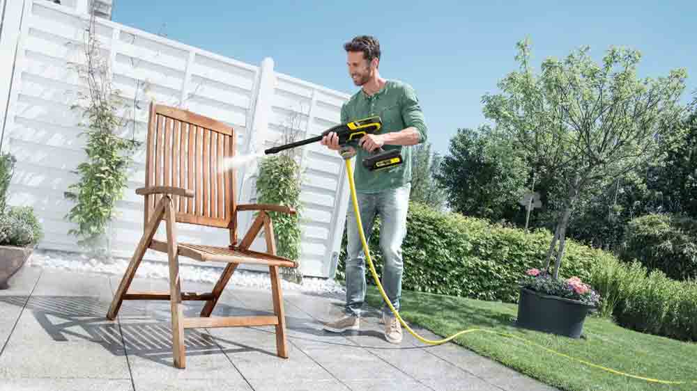 Muž čistí zahradní nábytek vysokotlakým čističem Kärcher KHB 6 Battery_02