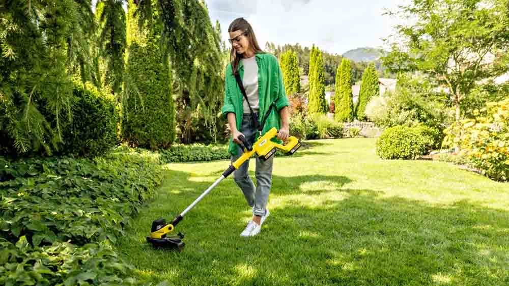 Žena seká trávník strunovouá zahradní sekačkou Kärcher LTR 3-18 Dual Battery Set_02