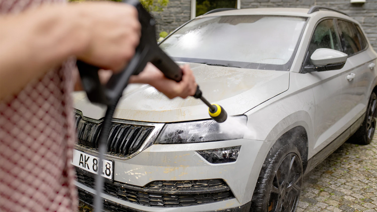 Muž um&yacute;v&aacute; auto myčkou K&auml;rcher