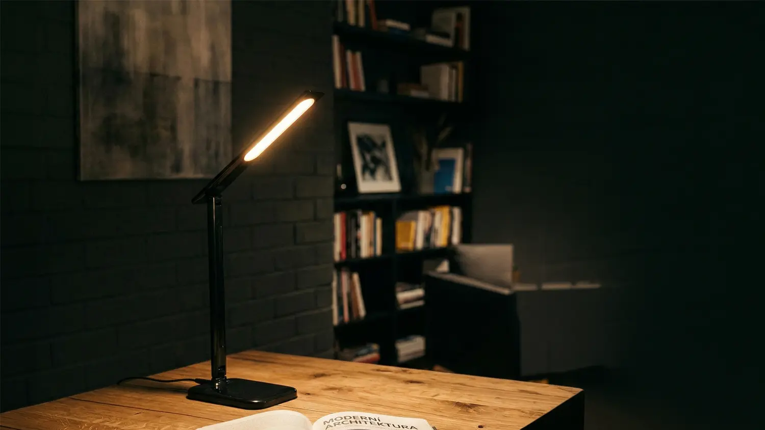Rozsvícená stolní lampa Retlux na stole s otevřenou knihou.