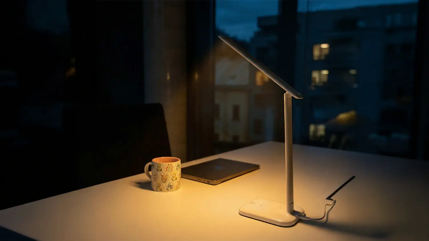 Rozsv&iacute;cen&aacute; stoln&iacute; lampa Retlux na stole s hrnkem a tabletem.
