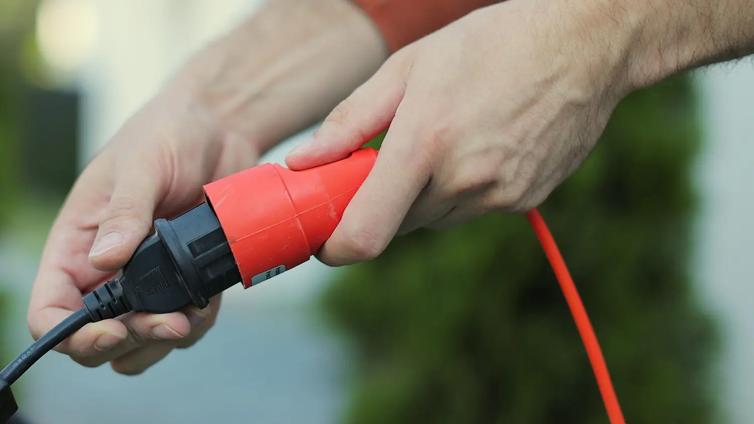 Kabel zahradn&iacute; sekačky zapojen&yacute; do prodlužovac&iacute;ho kabelu.