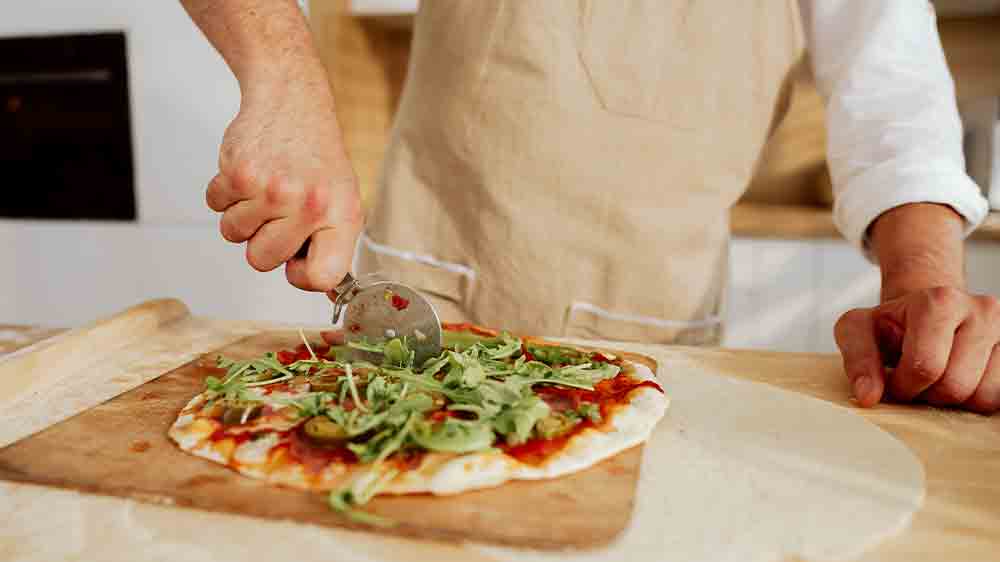 Muž krájející pizzu_03