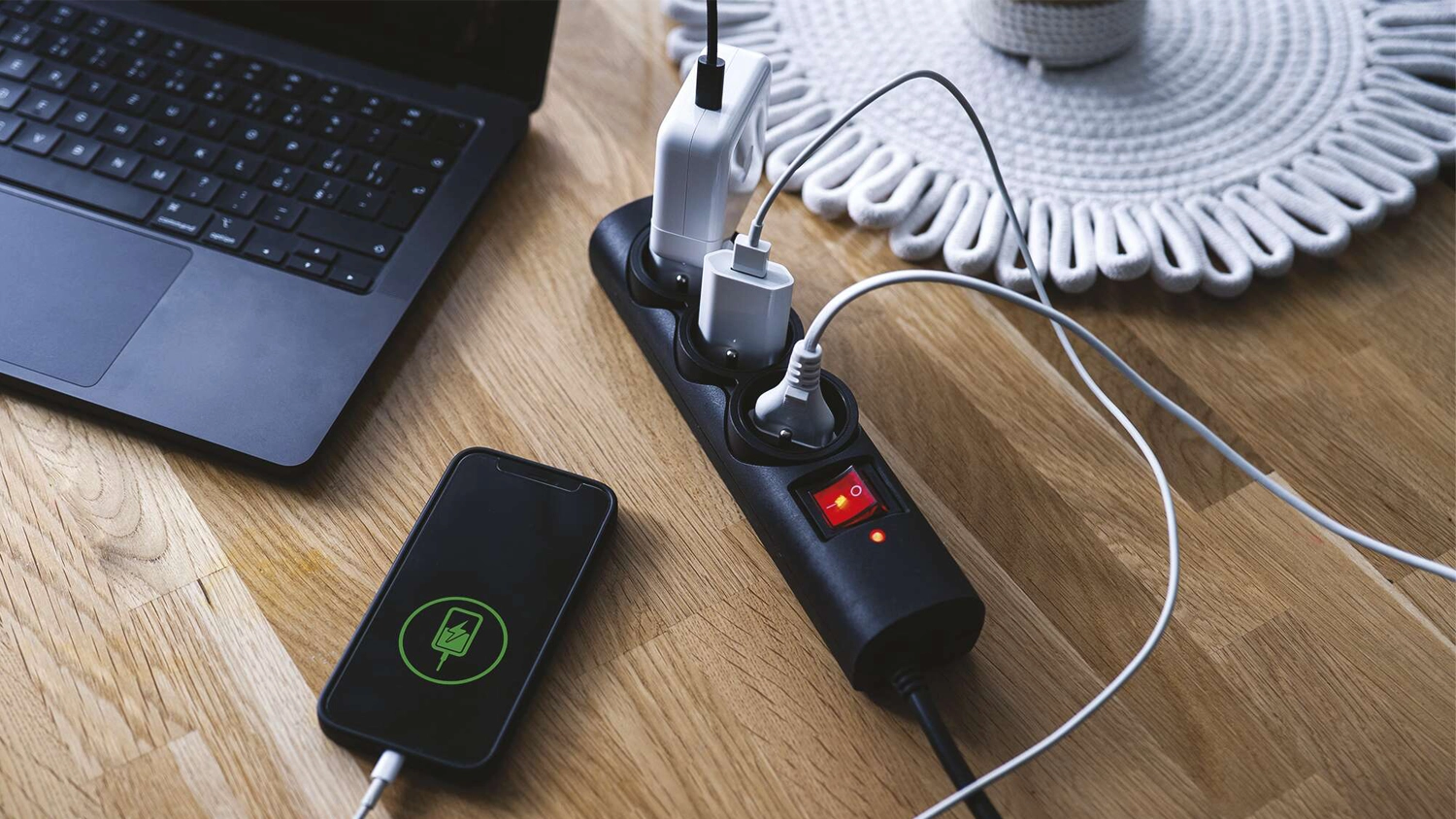 Prep&auml;ťov&aacute; ochrana EMOS 3 z&aacute;suvky 1,5m čierna na stole so zapojenou elektronikou