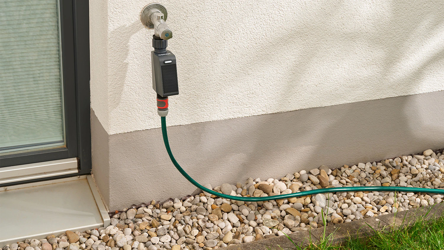 Regul&aacute;tor zavlažovania Osram SMART WI-FI IRRIGATION CONTROL pripojen&yacute; ku koh&uacute;tiku a hadici