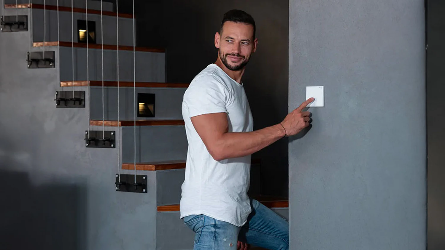 Muž stláča smart vypínač RETLUX RSH 301 Rodney