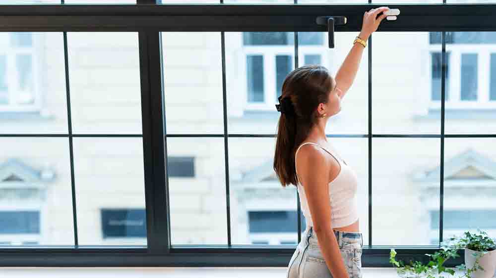 Žena nastavující smart senzor RETLUX RSH 307 Roland na okně _08