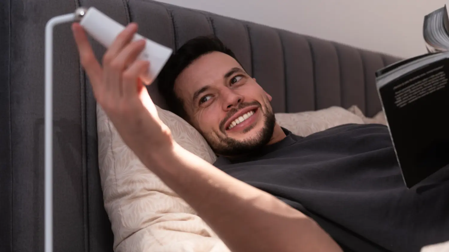 Muž si čte v posteli s nastavitelnou LED lampou 4v1 RETLUX RTL 209 LARA