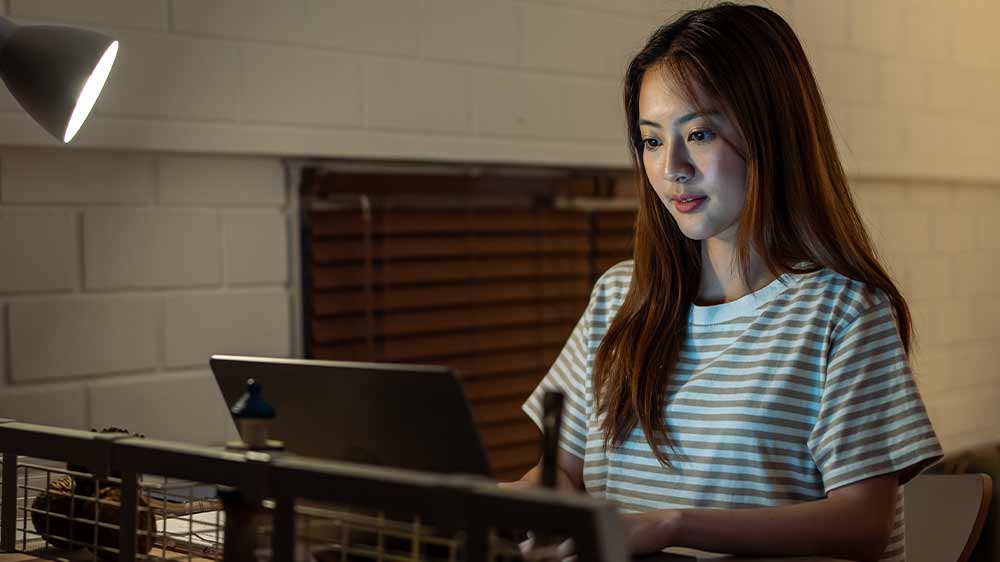 Žena pracujúca pri stole osvetlenom stolnou lampou _03