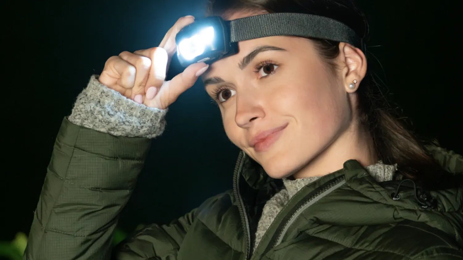 Žena s rozsvícenou čelovkou Retlux RPL 709 na hlavě