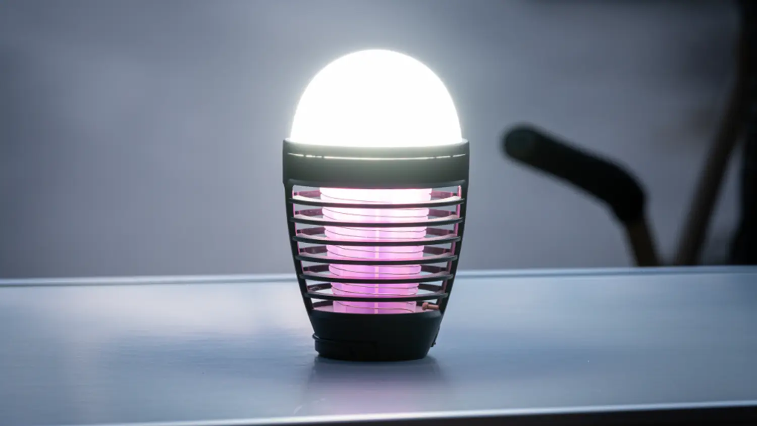 Lapač hmyzu se světlem RETLUX RGL 130 v noci na stolku