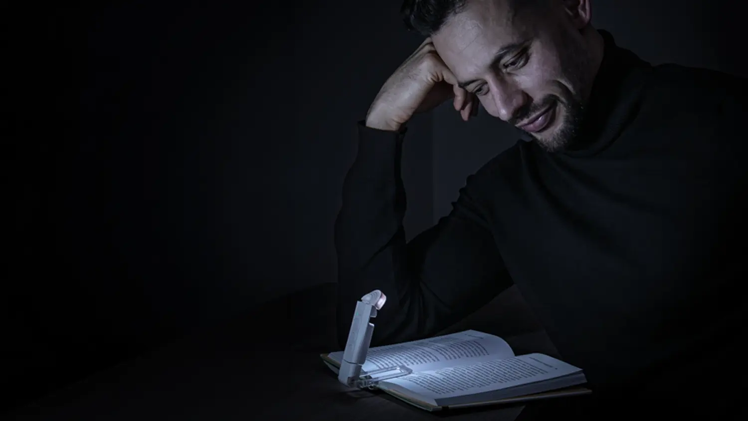 Muž čte ve tmě knihu s LED lampičkou na čtení Retlux RTL 213