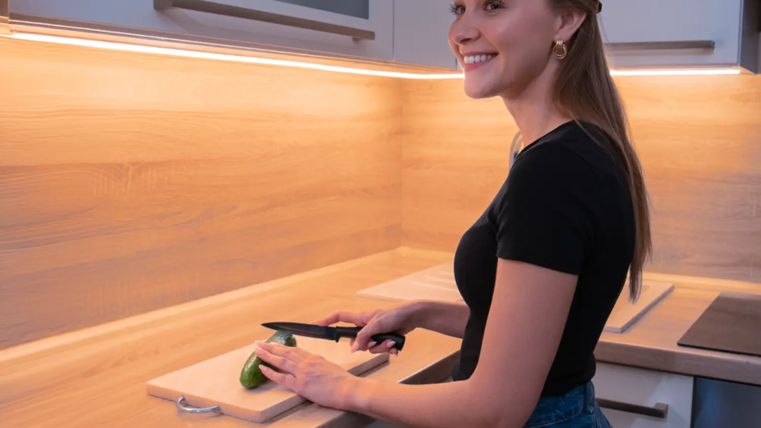 Žena je v kuchyni osvetlenej LED pásikom Retlux RLS 107