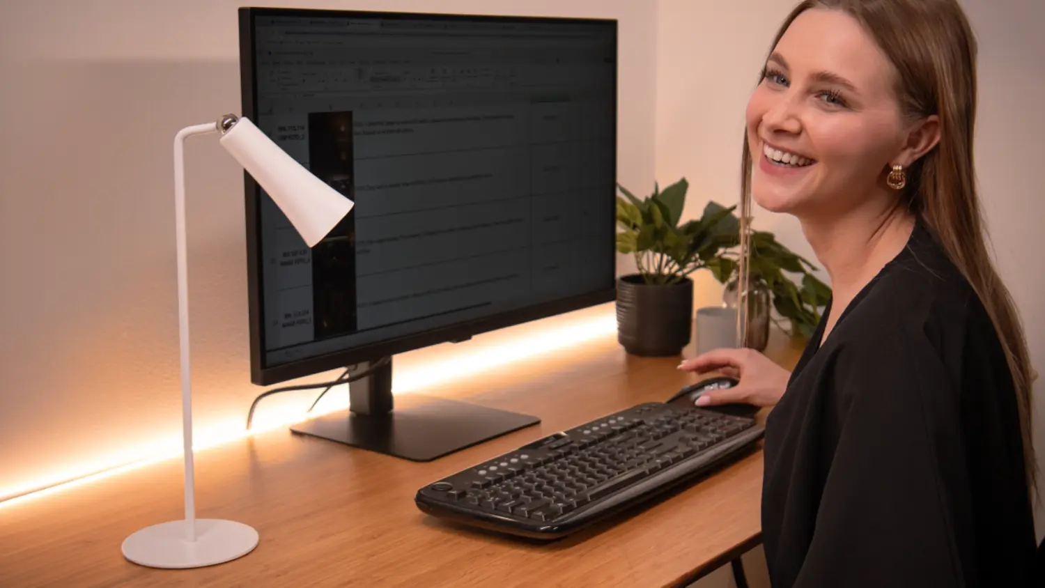 Žena sedí pri stole s počítačom osvetleným LED pásikom Retlux RLS 107