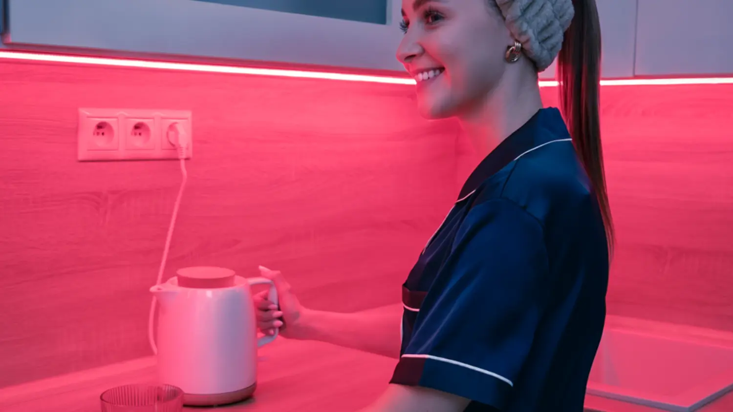 Žena je v kuchyni osvětlené LED páskem Retlux RLS 110 s červeným světlem
