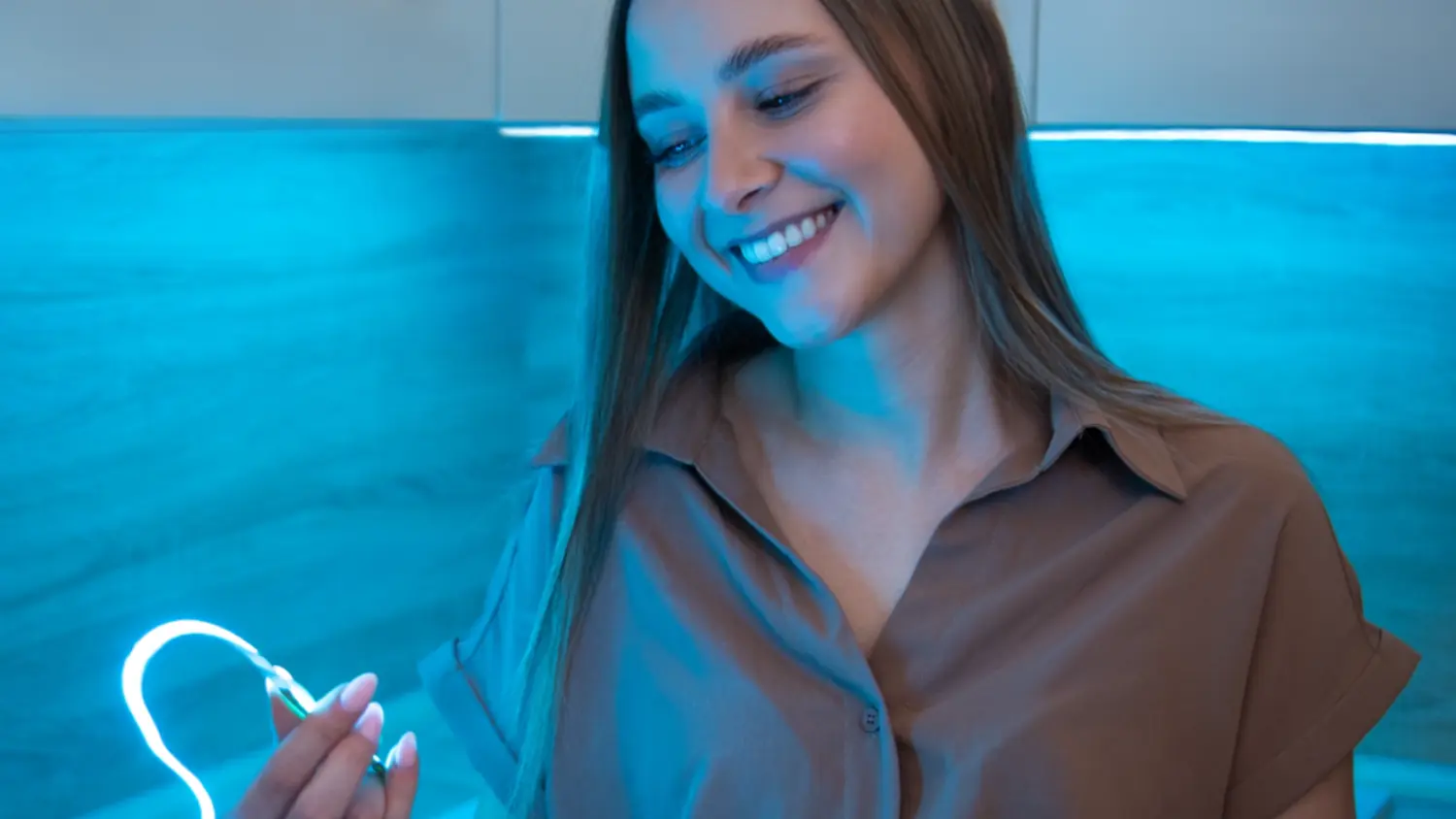 Žena v kuchyni s modře svítícím LED páskem Retlux RLS 110