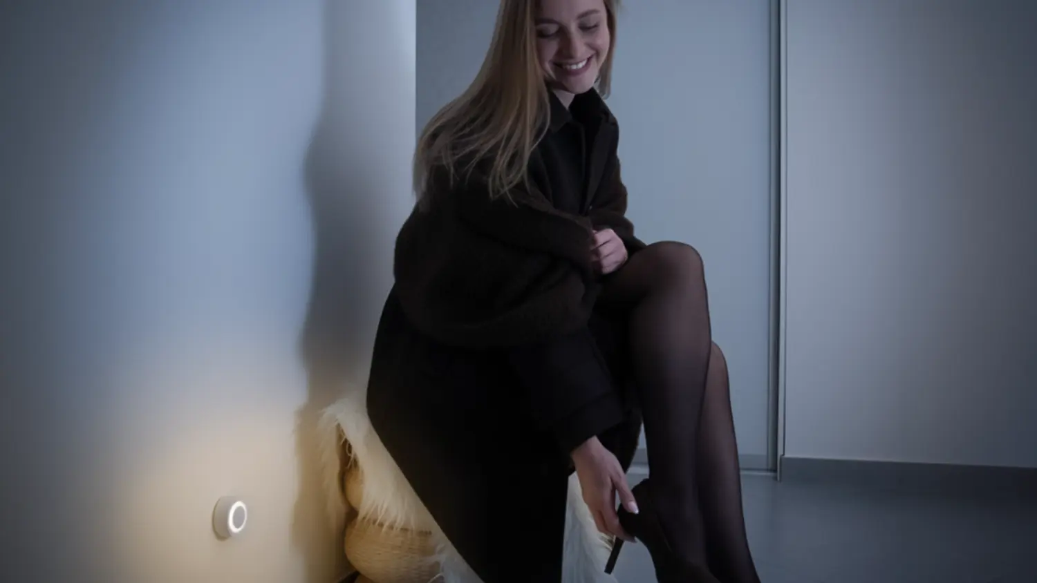 Žena si zouv&aacute; boty u LED světla Retlux RNL 114