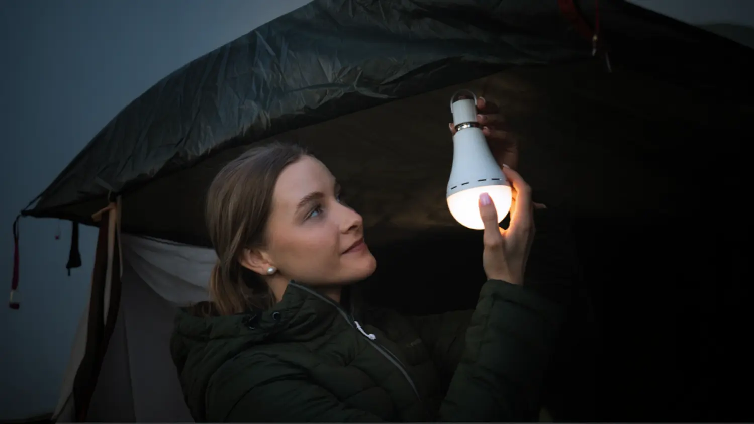 Žena instaluje nouzovou LED žárovku s baterií 3v1 Retlux RLL 671 ve stanu