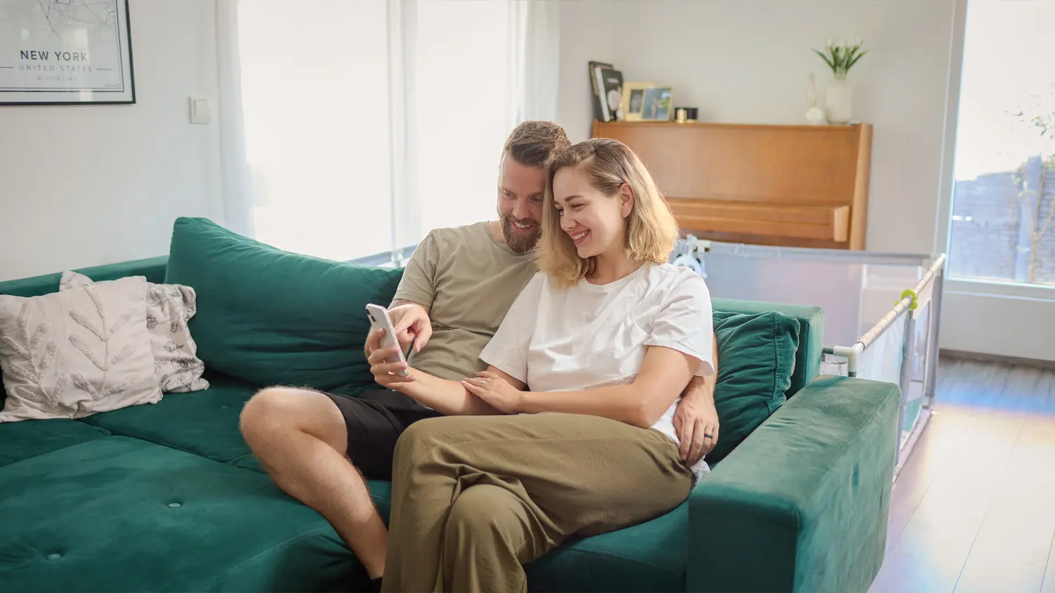 Pár v obývacím pokoji sledující obrazovku mobilního telefonu