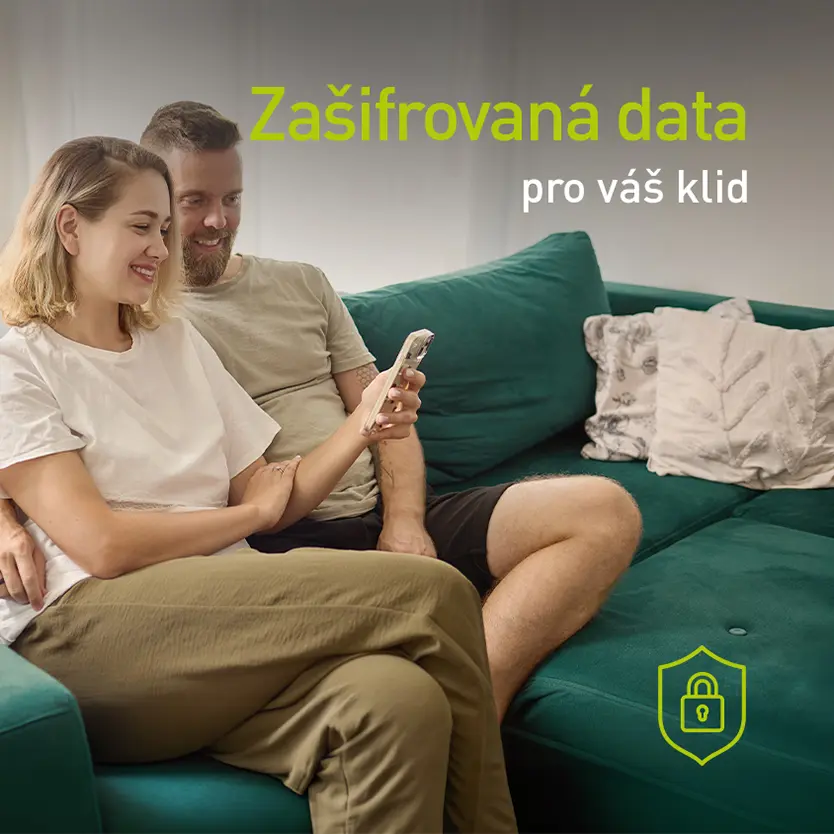 Pár na pohovce sledující mobilní telefon
