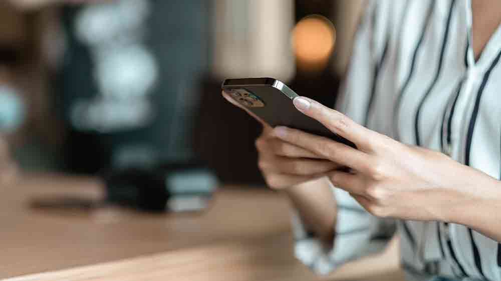 Ženské ruky držiace mobilný telefón