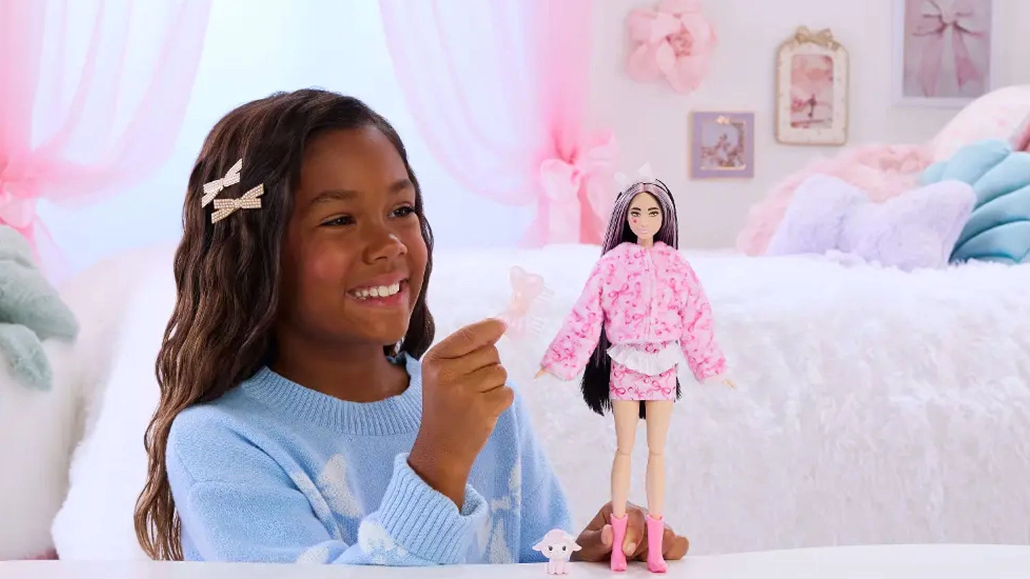Dívka drží plyšovou hlavu jehňátka vedle panenky Barbie Cutie Reveal v plyšovém kostýmu a malého mazlíčka.