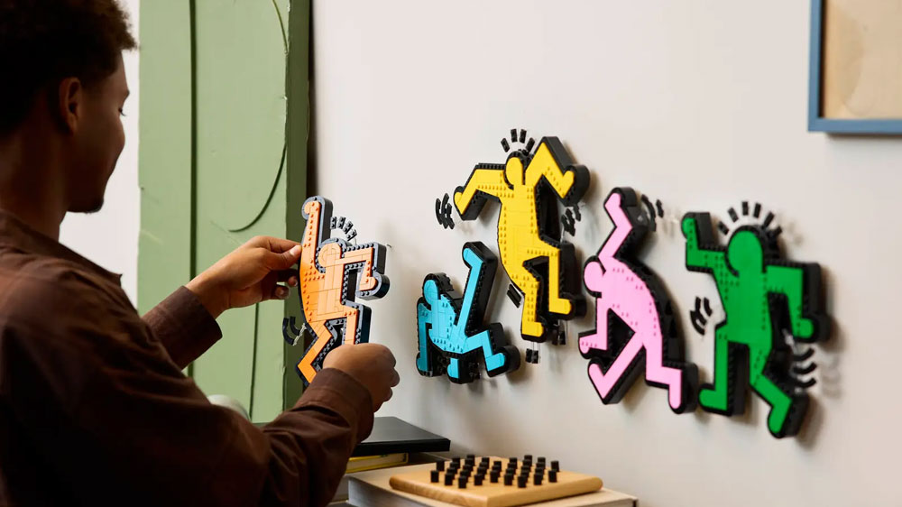 Muž přidělává jednotlivé figurky ze stavebnice LEGO® Art 31216 Keith Haring – Tančící postavy na stěnu_03