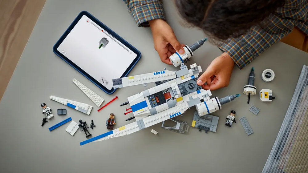 Dívka sestavuje stavebnici LEGO® Star Wars™ 75399 Povstalecká stíhačka U-wing s pomocí aplikace LEGO® Builder na tabletu_03